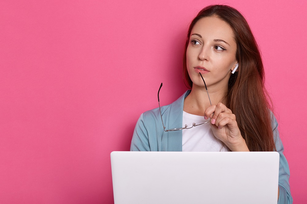 Mujer pensativa frente a laptop