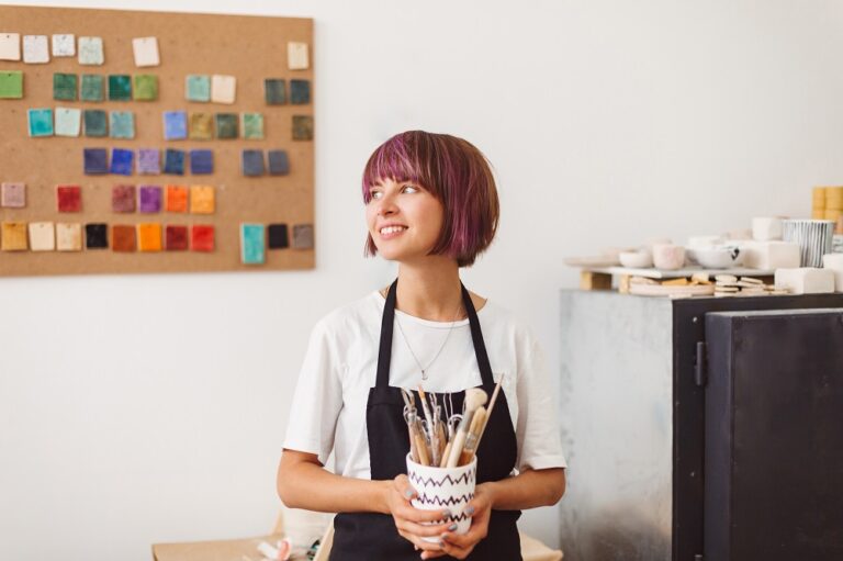 Emprendedora con pinceles y muestras de colores trabaja en un moodboard