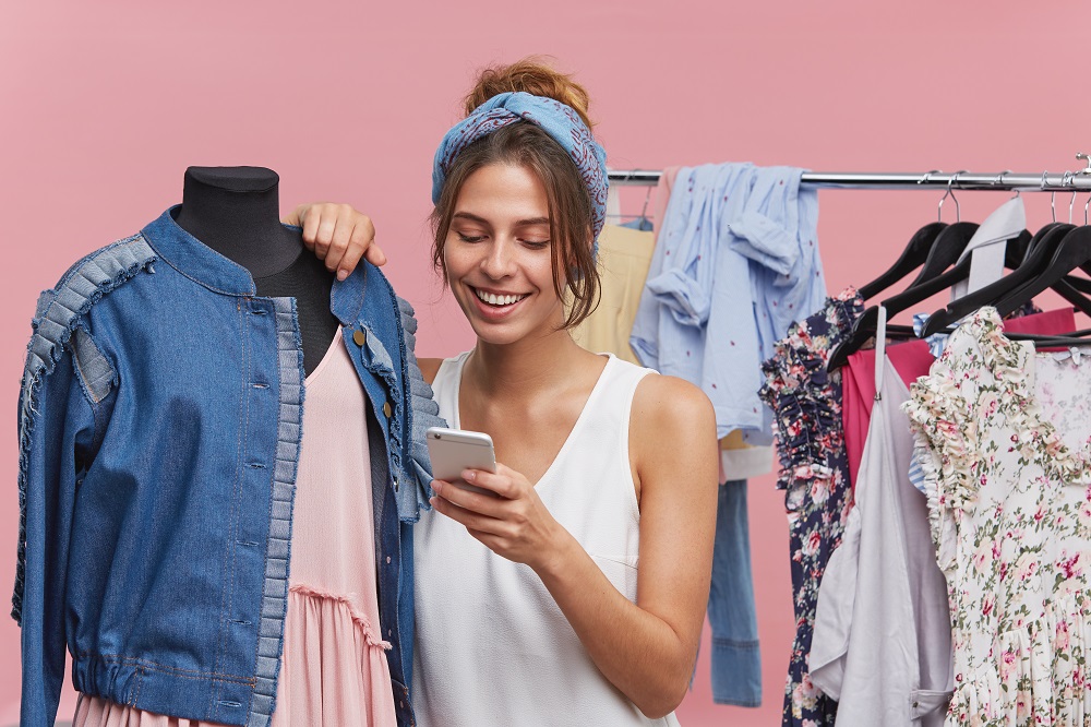 Cómo vender por internet ropa: vendedora de ropa escribe por celular