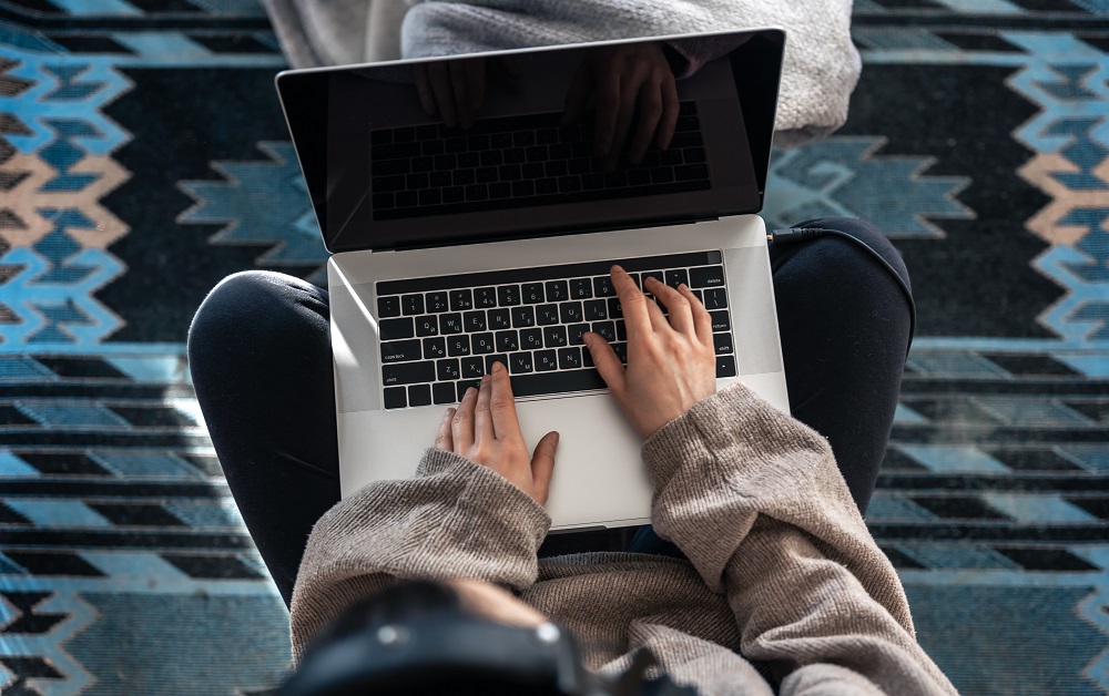 Mujer escribe en laptop ficha de producto